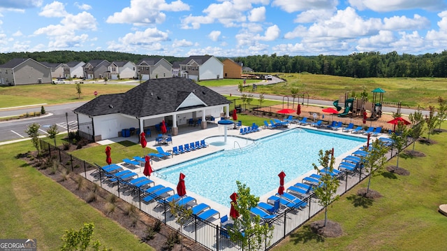 view of swimming pool featuring a lawn and a patio