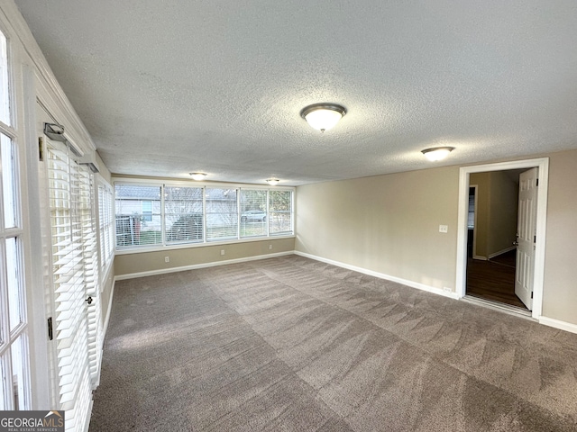 unfurnished room with carpet flooring and a textured ceiling