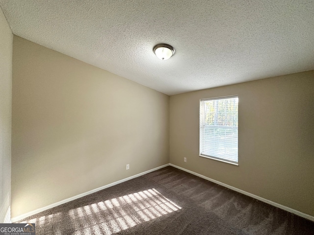 carpeted spare room with a textured ceiling