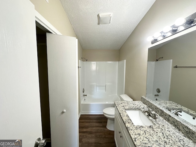 full bathroom with hardwood / wood-style floors, shower / bathing tub combination, vanity, toilet, and a textured ceiling