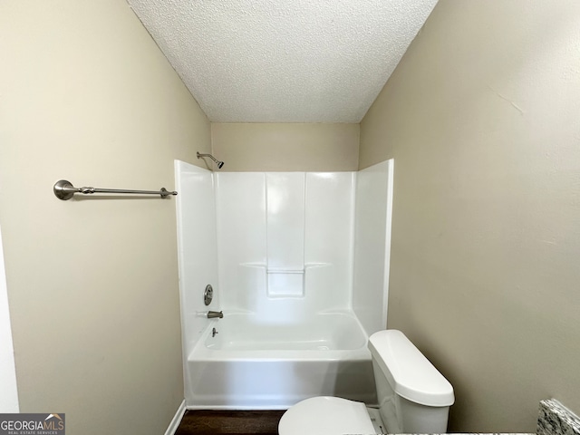 bathroom with shower / tub combination, a textured ceiling, and toilet