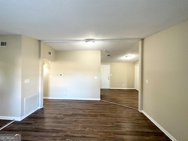 spare room with dark wood-type flooring and a textured ceiling