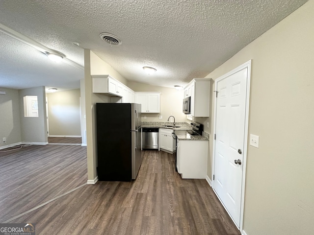 kitchen featuring dark wood-type flooring, sink, a textured ceiling, white cabinetry, and stainless steel appliances