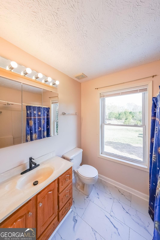 bathroom with vanity, a textured ceiling, and toilet