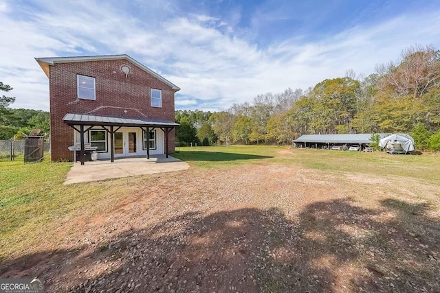 rear view of property with a patio and a yard