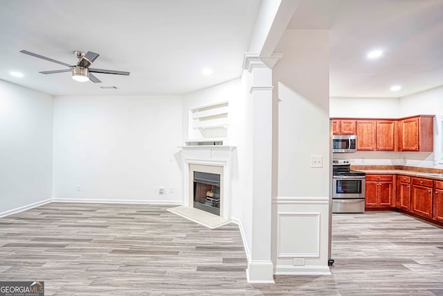 kitchen with ceiling fan, stainless steel appliances, and light hardwood / wood-style floors