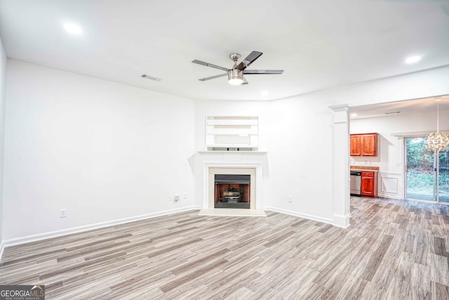 unfurnished living room with light hardwood / wood-style floors and ceiling fan with notable chandelier