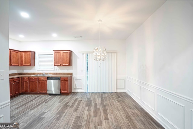 kitchen featuring pendant lighting, sink, stainless steel dishwasher, light hardwood / wood-style floors, and a chandelier