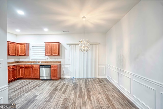 kitchen featuring dishwasher, sink, decorative light fixtures, light wood-type flooring, and a notable chandelier