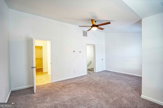 carpeted spare room with ceiling fan and lofted ceiling