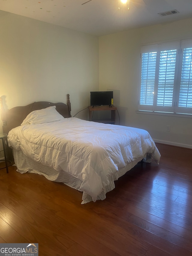 bedroom with ceiling fan and dark hardwood / wood-style flooring