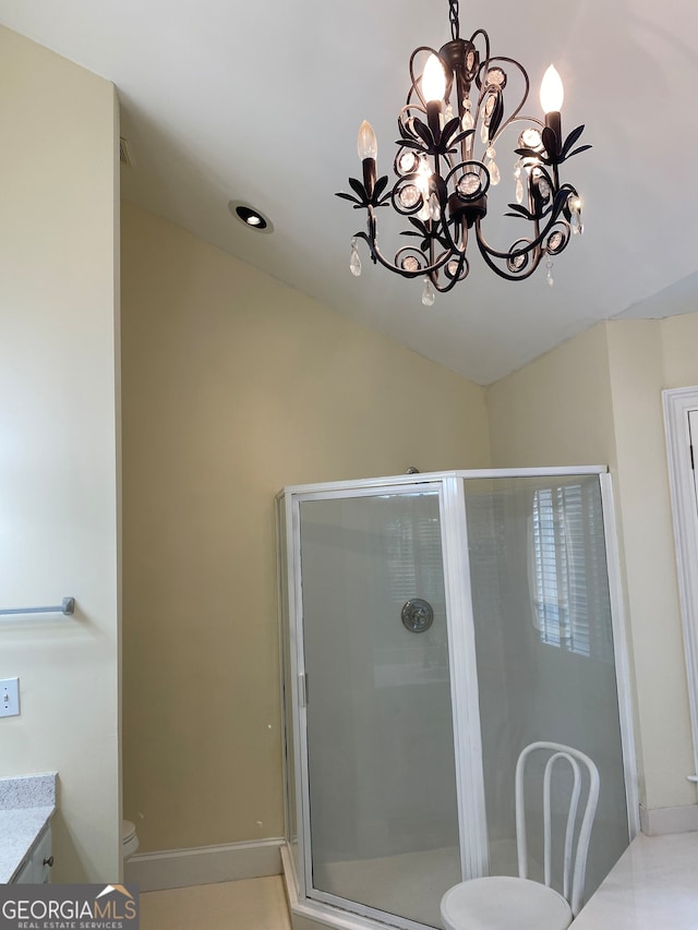 bathroom with a notable chandelier, toilet, a shower with shower door, and vanity