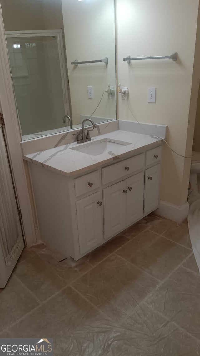 bathroom featuring tile patterned floors, vanity, and toilet