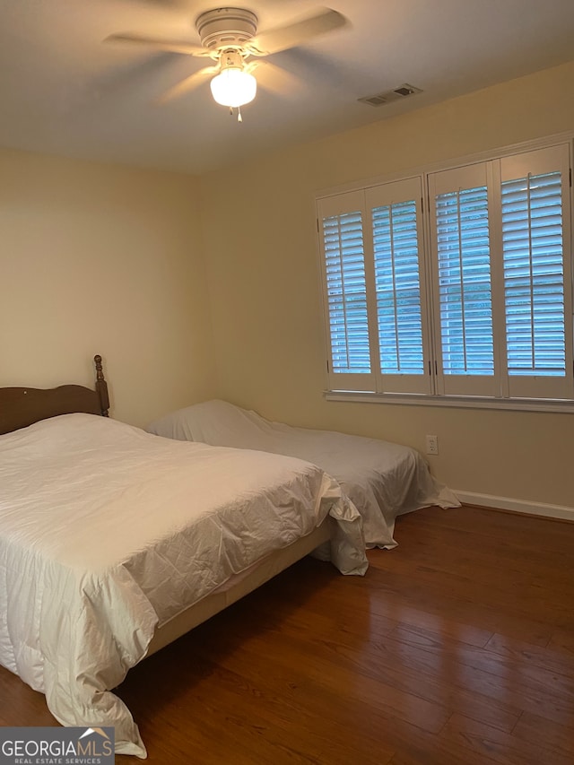 bedroom with ceiling fan and dark hardwood / wood-style floors