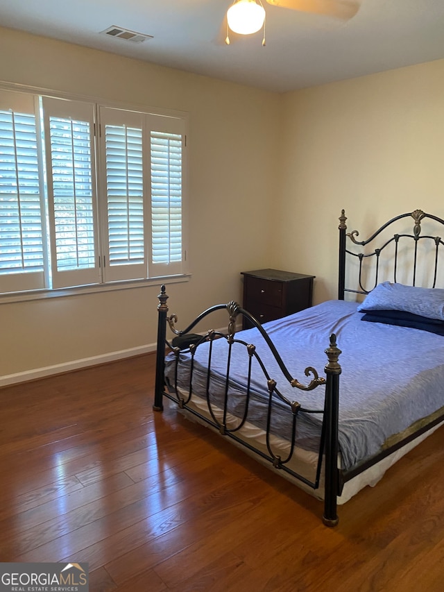 bedroom with ceiling fan and dark hardwood / wood-style flooring