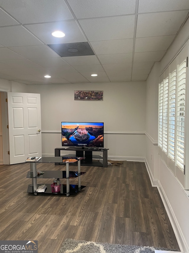 interior space featuring a paneled ceiling and dark hardwood / wood-style flooring