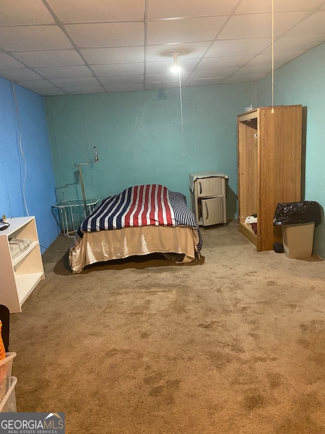 bedroom featuring carpet floors and a drop ceiling