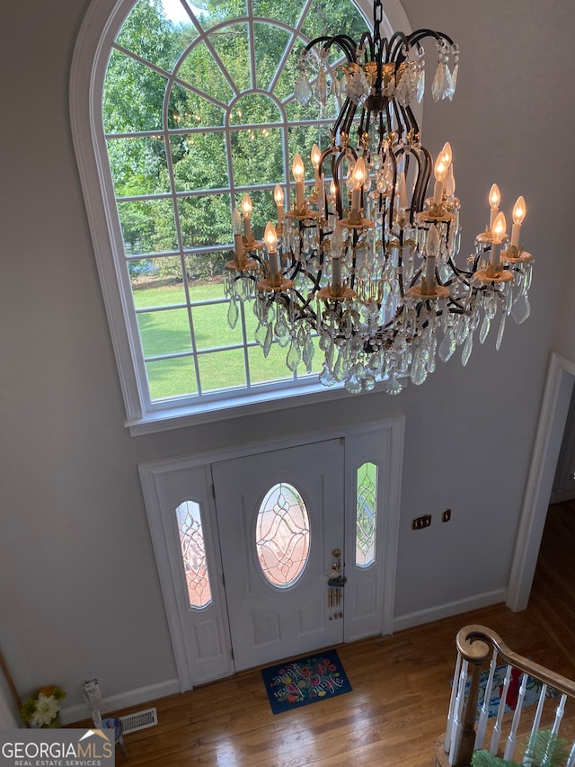 entryway featuring hardwood / wood-style flooring and a notable chandelier