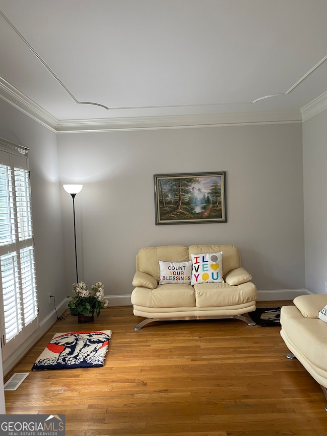 living room featuring hardwood / wood-style floors and crown molding