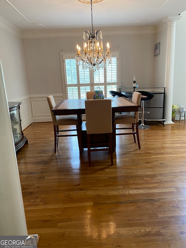 dining area featuring crown molding, dark wood-type flooring, and an inviting chandelier