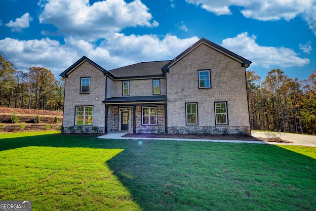 traditional-style house featuring a front lawn and brick siding