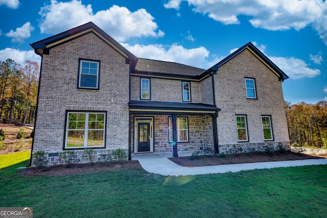 traditional-style house featuring a porch, a front yard, stone siding, and brick siding