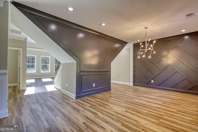 bonus room featuring light wood finished floors, visible vents, and a decorative wall