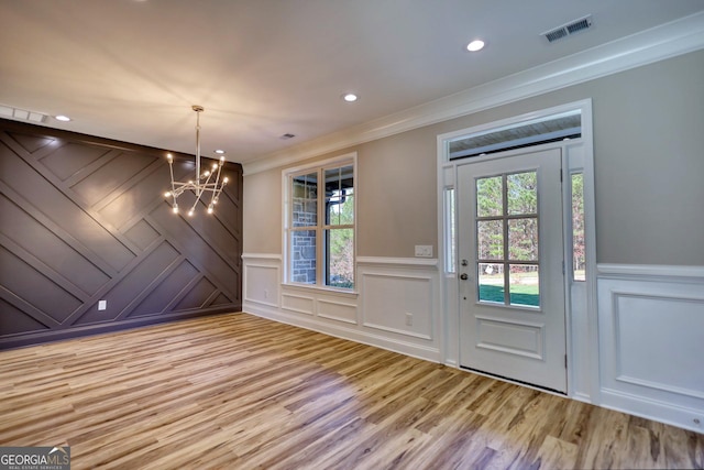 interior space featuring a healthy amount of sunlight, visible vents, crown molding, and light wood finished floors