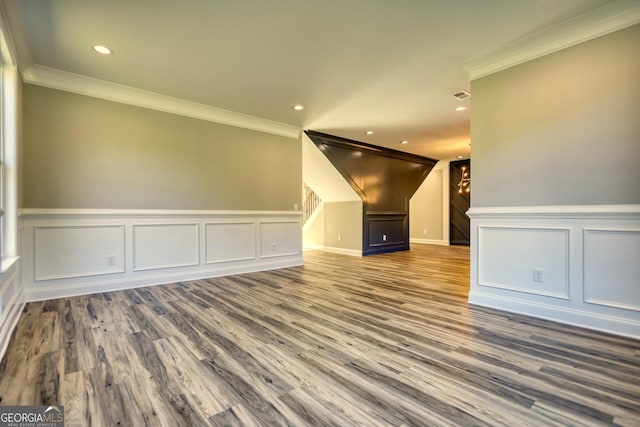 interior space with ornamental molding, wood finished floors, and recessed lighting