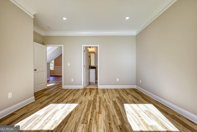 unfurnished bedroom featuring ornamental molding, light wood-type flooring, and baseboards