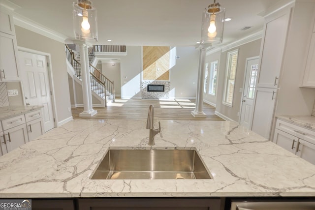 kitchen featuring a sink, white cabinetry, and pendant lighting