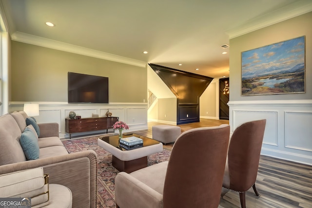 living room with recessed lighting, visible vents, crown molding, and a decorative wall