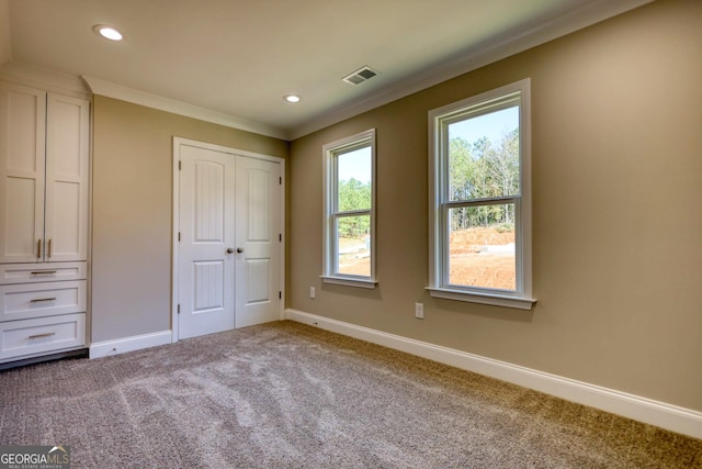 unfurnished bedroom with baseboards, visible vents, crown molding, carpet flooring, and recessed lighting