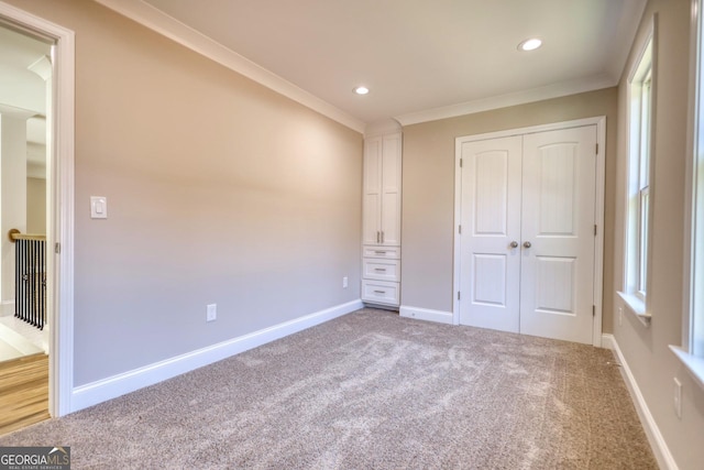 unfurnished bedroom featuring crown molding, recessed lighting, a closet, carpet flooring, and baseboards