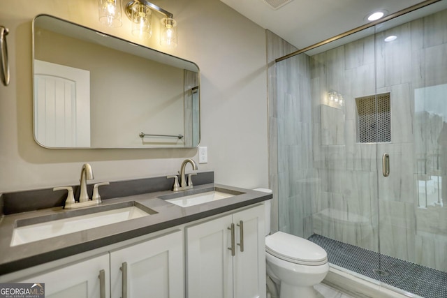 full bathroom with a sink, a shower stall, toilet, and double vanity