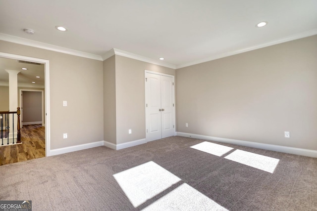 unfurnished bedroom featuring carpet floors, crown molding, and baseboards