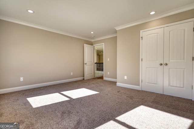 unfurnished bedroom featuring carpet, recessed lighting, a closet, ornamental molding, and baseboards