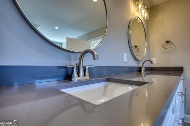 interior details featuring double vanity, a sink, and recessed lighting