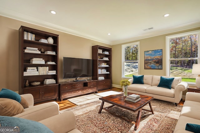 living room with light wood-style flooring, visible vents, crown molding, and recessed lighting