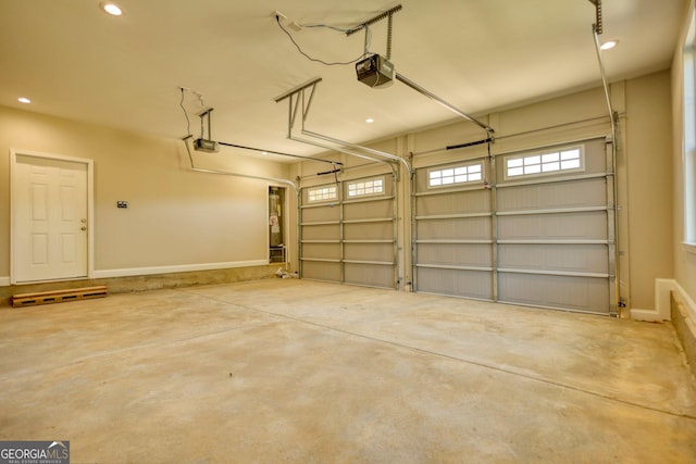 garage with recessed lighting, baseboards, and a garage door opener