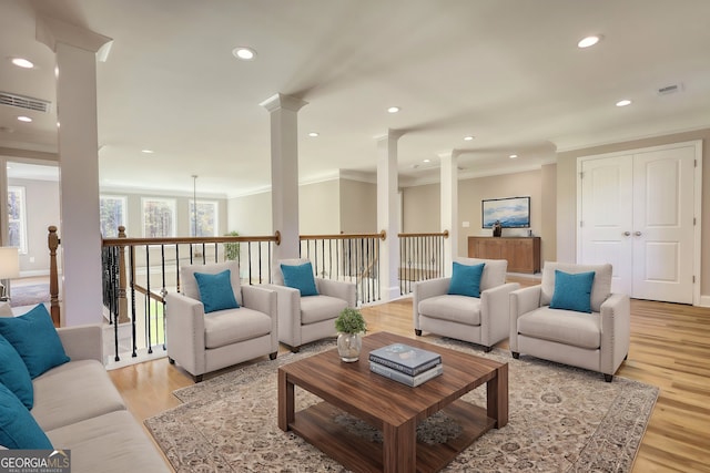 living room with ornamental molding, decorative columns, and light wood-style floors