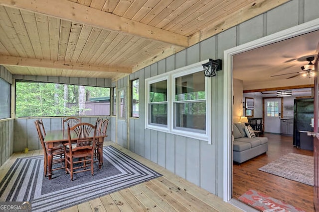 sunroom featuring beam ceiling, a wealth of natural light, wooden ceiling, and ceiling fan