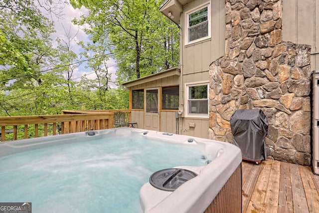 deck featuring a sunroom and a hot tub