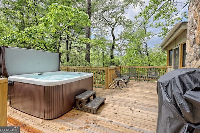 wooden terrace with a hot tub and grilling area