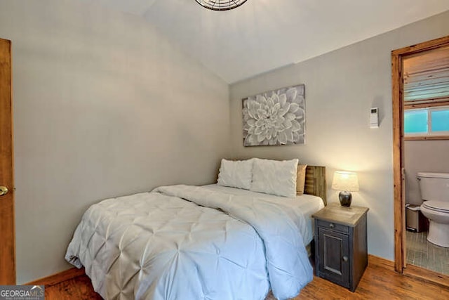 bedroom with wood-type flooring and vaulted ceiling