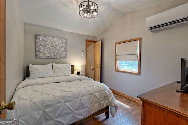 bedroom featuring lofted ceiling, wood-type flooring, and an AC wall unit