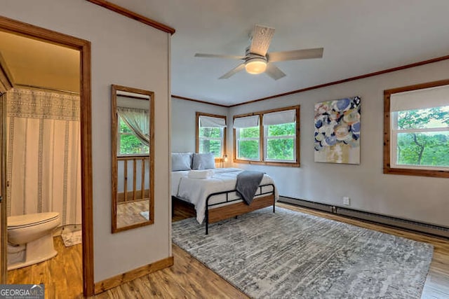 bedroom featuring ceiling fan, light wood-type flooring, baseboard heating, and multiple windows