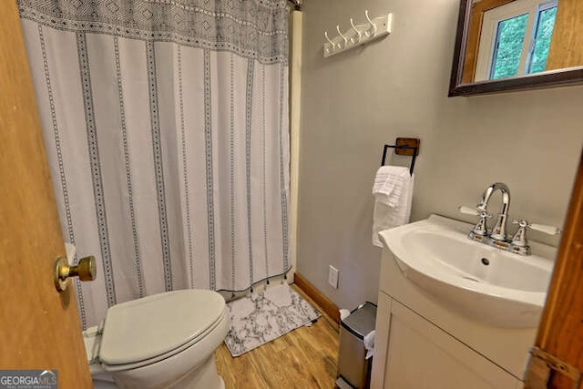 bathroom featuring a shower with curtain, vanity, wood-type flooring, and toilet