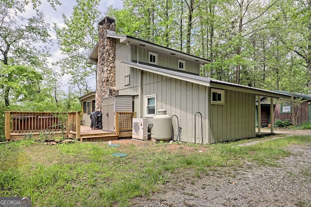 rear view of house with ac unit and a wooden deck