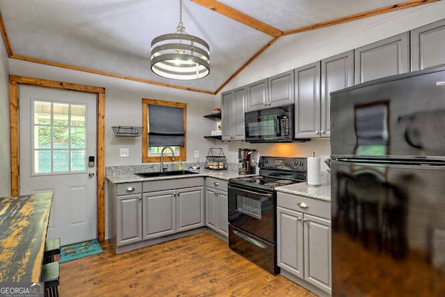 kitchen featuring sink, light hardwood / wood-style flooring, vaulted ceiling, gray cabinets, and black appliances